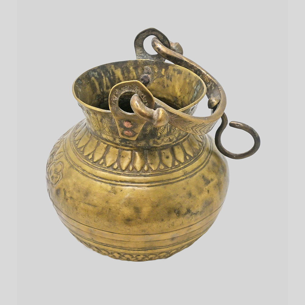 Antique brass holy water pot with engraved floral and traditional figures, side view