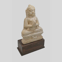 Hand-carved seated Jain Lord Mahavira statue on wooden display base, angled view