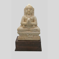 Hand-carved seated Jain Lord Mahavira statue on wooden display base, close-up detail