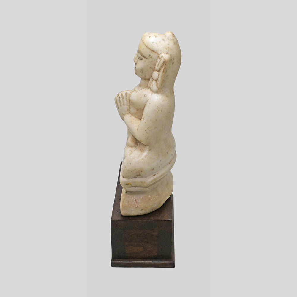 Hand-carved seated Jain Lord Mahavira statue on wooden display base, side view