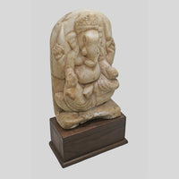 Vintage marble Hindu Lord Ganesha statue on wooden base, angled view