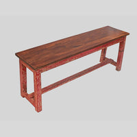 Vintage handcrafted long wooden bench with distressed red finish, angled view