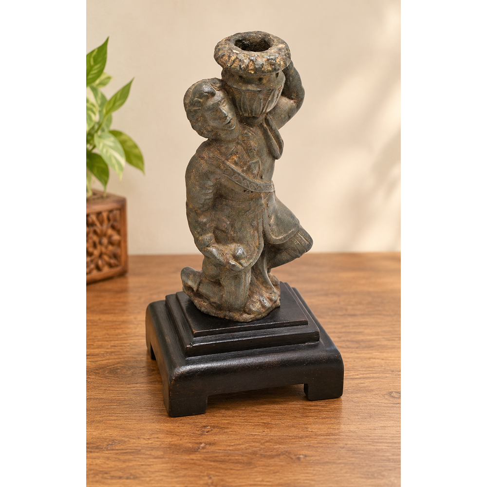 Antique cast metal man figurine carrying a pot, decorative candle holder, front view