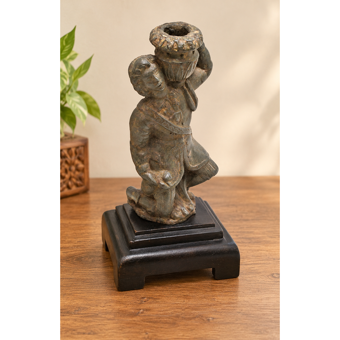 Antique cast metal man figurine carrying a pot, decorative candle holder, front view