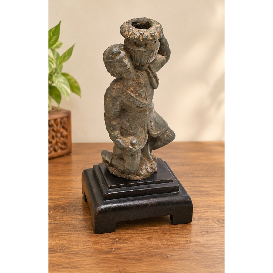 Antique cast metal man figurine carrying a pot, decorative candle holder, front view