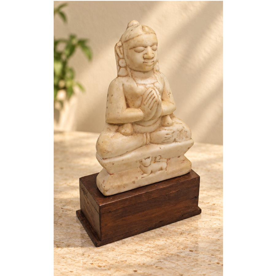 Hand-carved seated Jain Lord Mahavira statue on wooden display base, front view