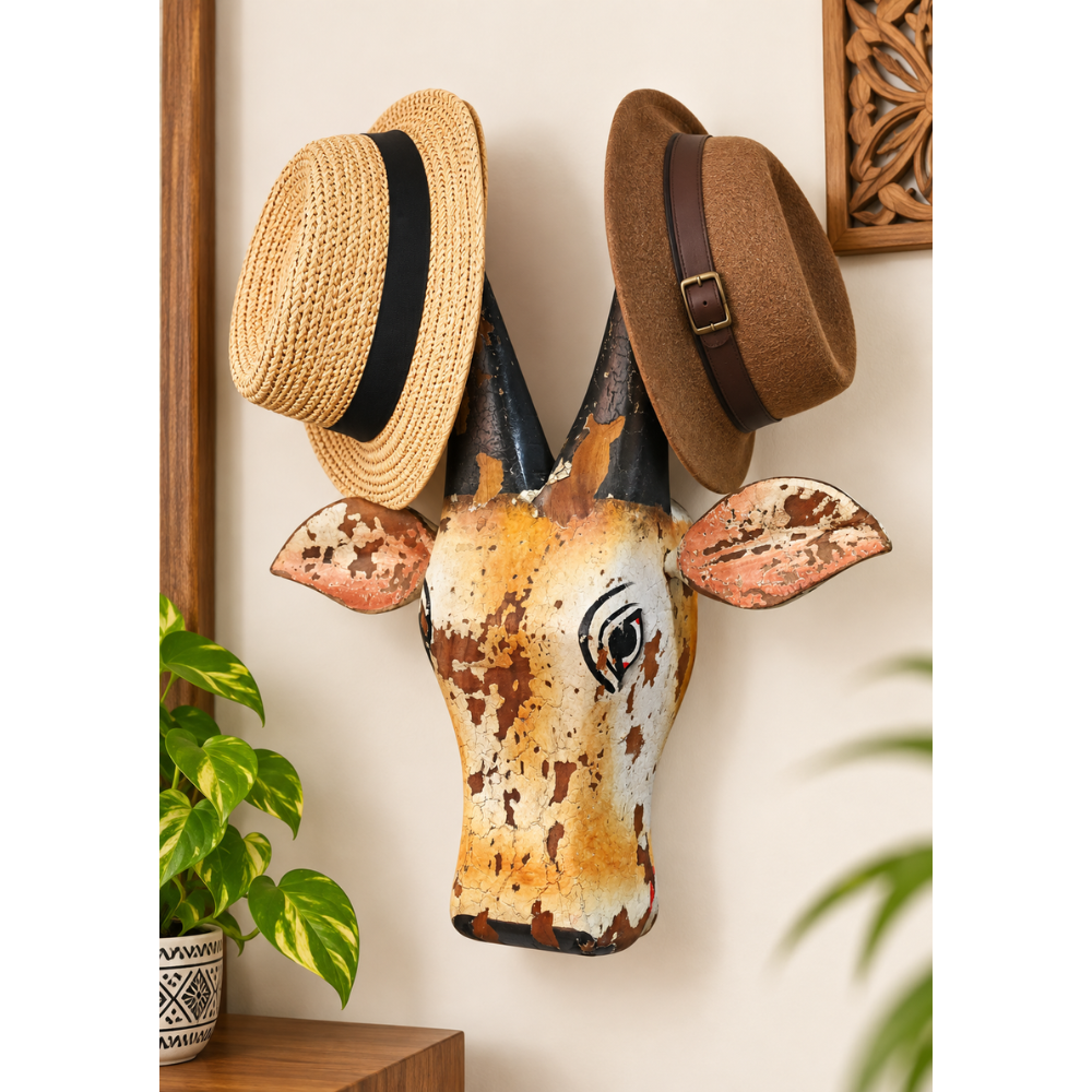 Yellow and white painted wooden cow head hat hanger, front view