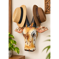 Yellow and white painted wooden cow head hat hanger, front view