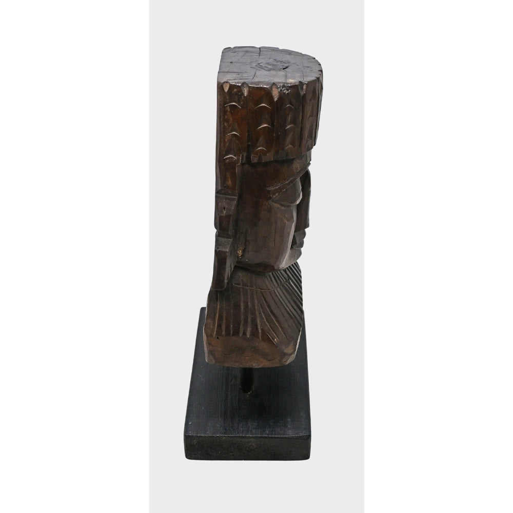 Angled view of antique wooden tribal face sculpture
