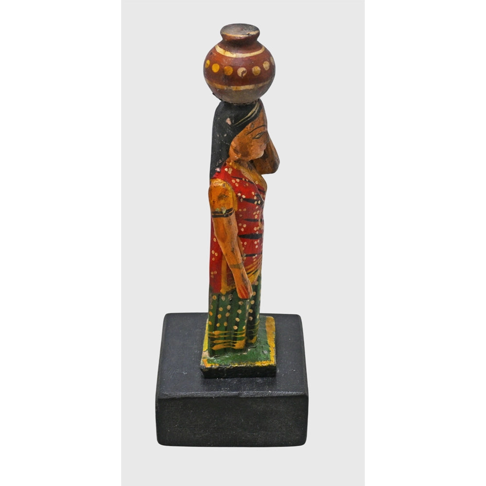 Side view of wooden Indian lady with water pot