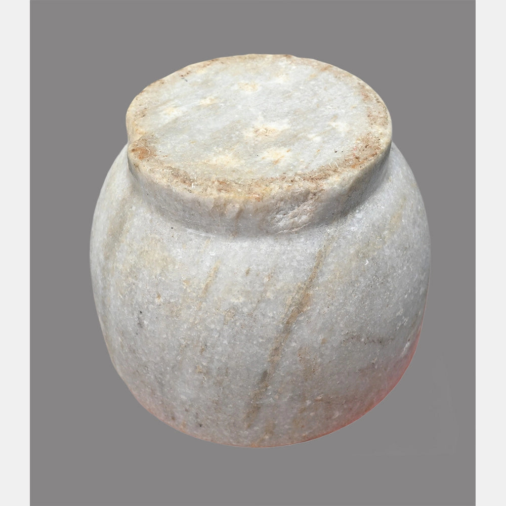 Angled view of antique white marble grinding bowl